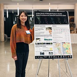 Chu Li standing in front of our sidewalk equity poster at the PacTrans conference
