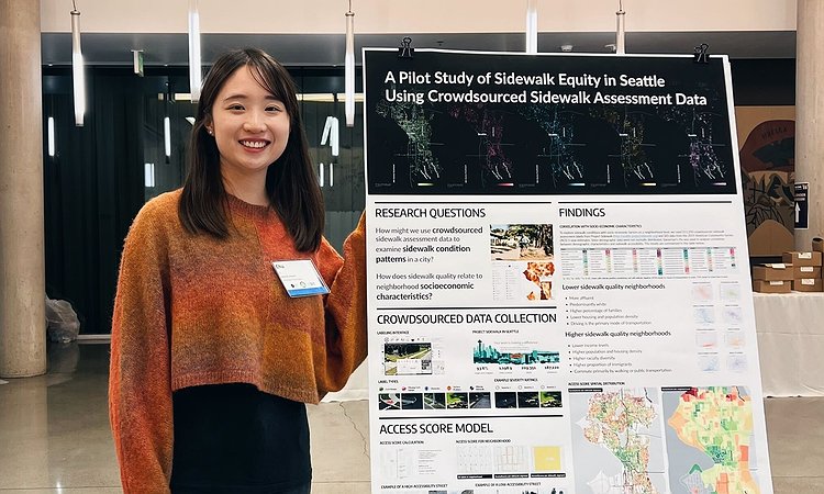 Chu Li standing in front of our sidewalk equity poster at the PacTrans conference