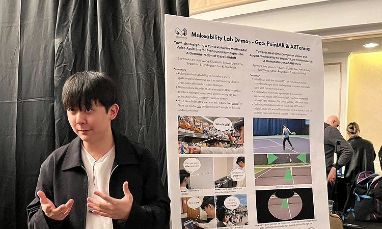 Jae Lee standing at the UIST'23 booth presenting both ARTennis and GazePointAR
