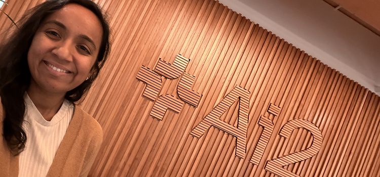 Arnavi standing in front of AI2 sign
