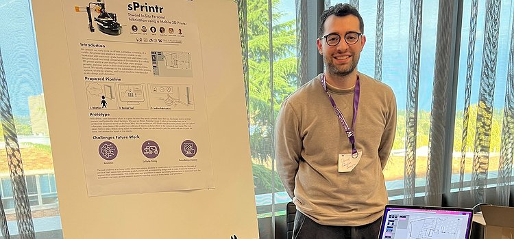 Daniel Campos Zamora standing in front of sPrintr and his poster at SCF