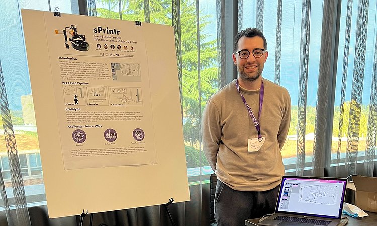 Daniel Campos Zamora standing in front of sPrintr and his poster at SCF