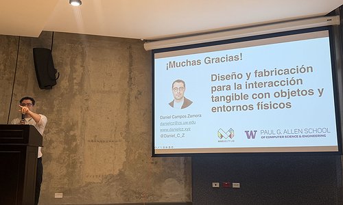 Daniel standing in front of the room at a podium with his slides
