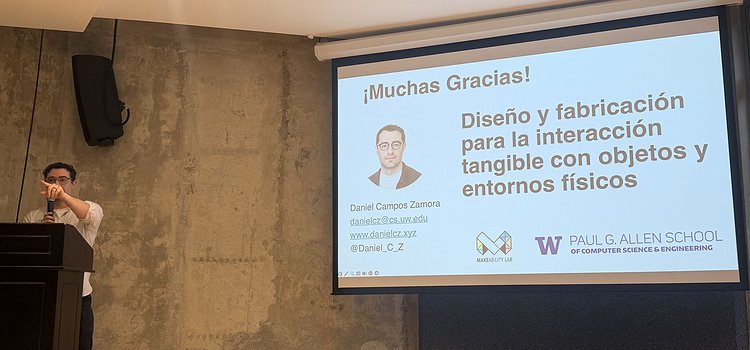 Daniel standing in front of the room at a podium with his slides