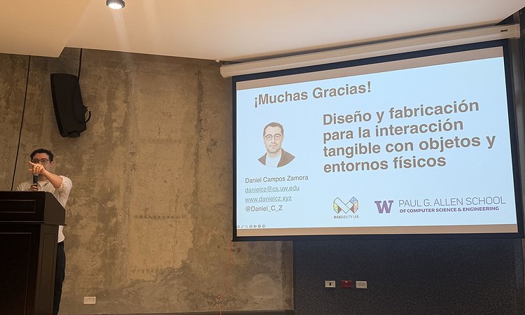 Daniel standing in front of the room at a podium with his slides