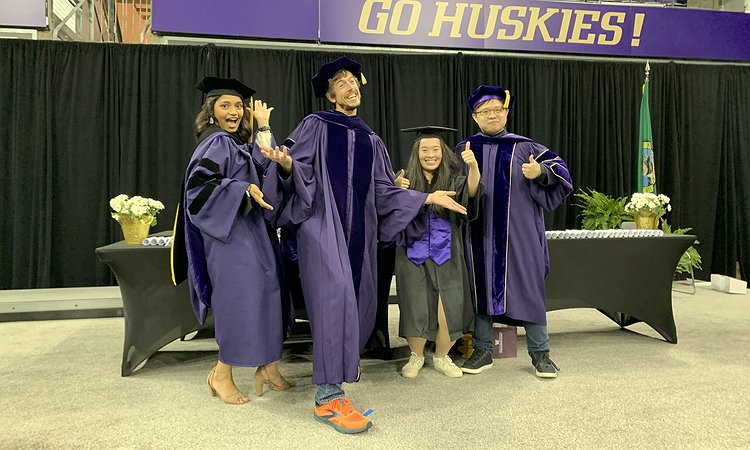 An image of Manaswi, Jon, Aileen, and Liang in their graduation gowns and making silly faces