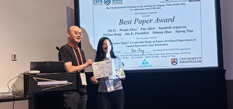 Receicing the best paper award in front of the title slide at the workshop