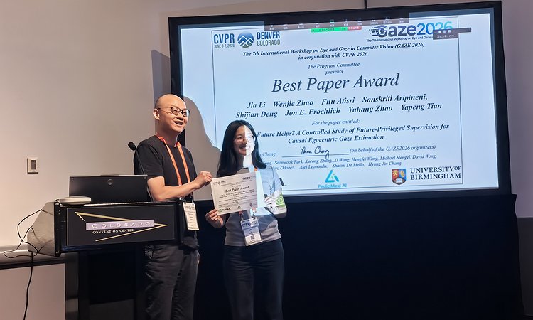 Receicing the best paper award in front of the title slide at the workshop