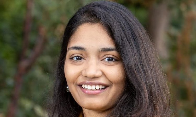 A picture of Manaswi Saha showing her standing in front of tree with a yellow shirt