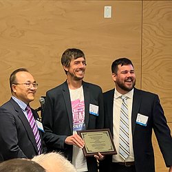 PacTrans Director Yinhai Wang and Assistant Director Cole Kopca giving Jon Froehlich the PacTrans award plaque