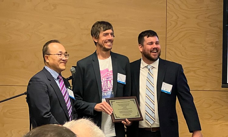 PacTrans Director Yinhai Wang and Assistant Director Cole Kopca giving Jon Froehlich the PacTrans award plaque
