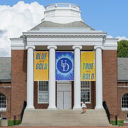Picture of a University of Delaware campus showing a brick building and some UDelaware banners