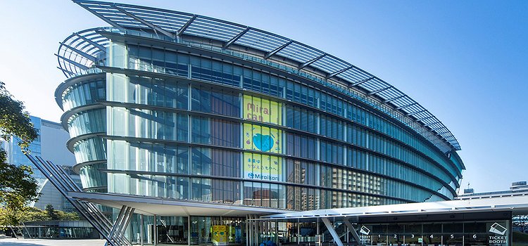The Miraikan museum building. A modern oval shaped building with a sleek glass exterior.