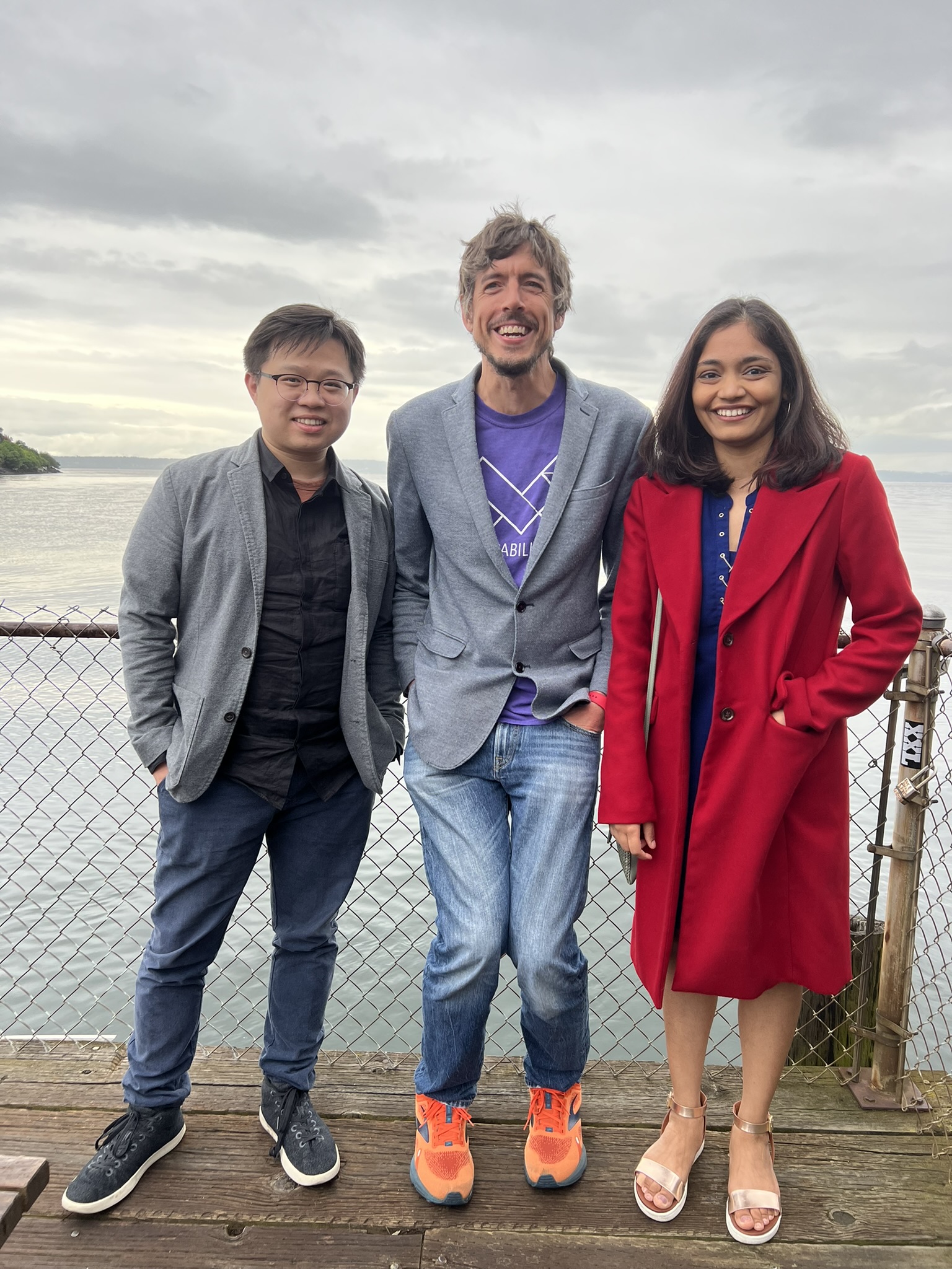 A picture of Liang, Jon, and Manaswi standing on a pier in front of the Puget Sound by Ray's Boathouse