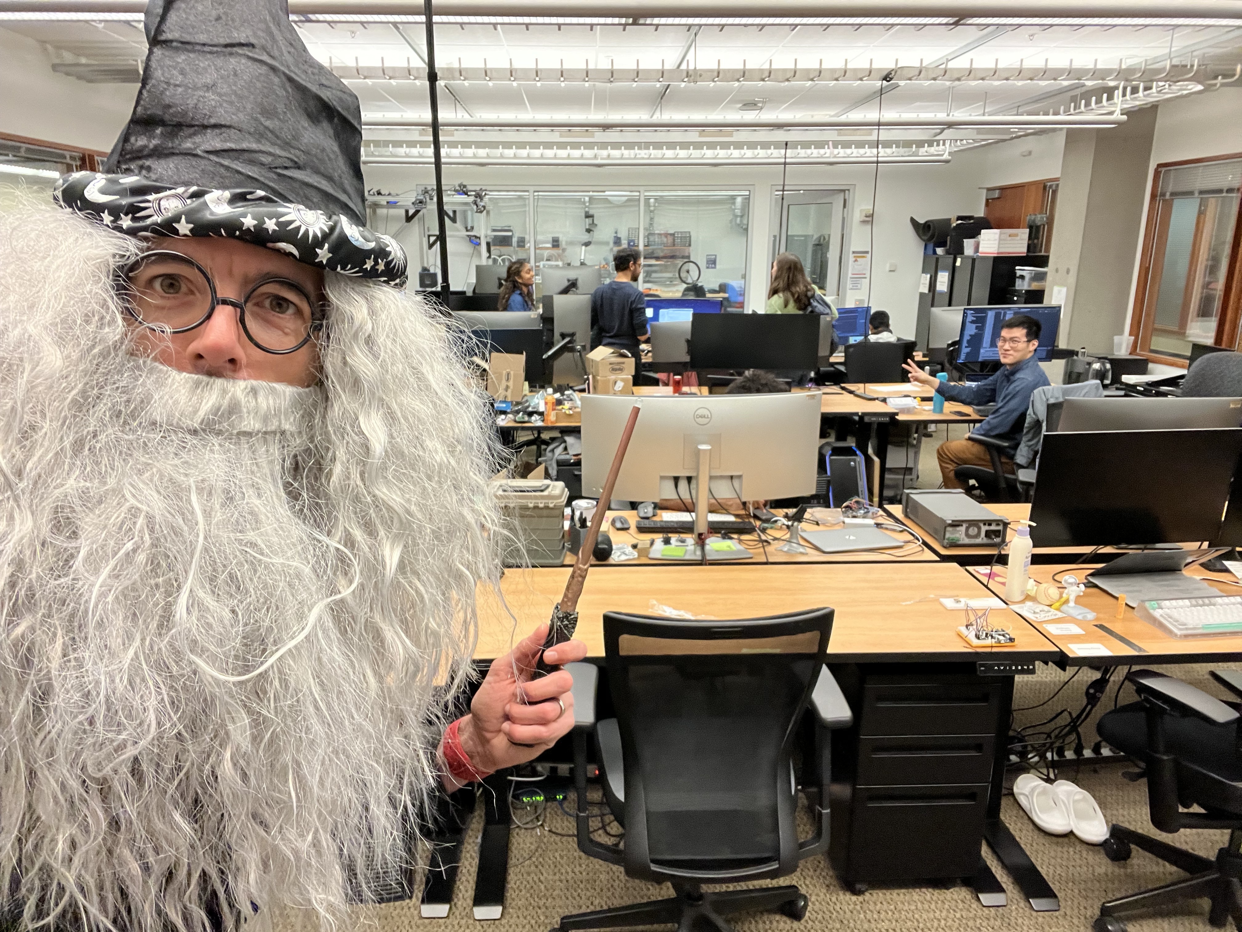 Professor Froehlich dressed up as Dumbledore with a wizard hat, hair, and beard. He is holding a wand.