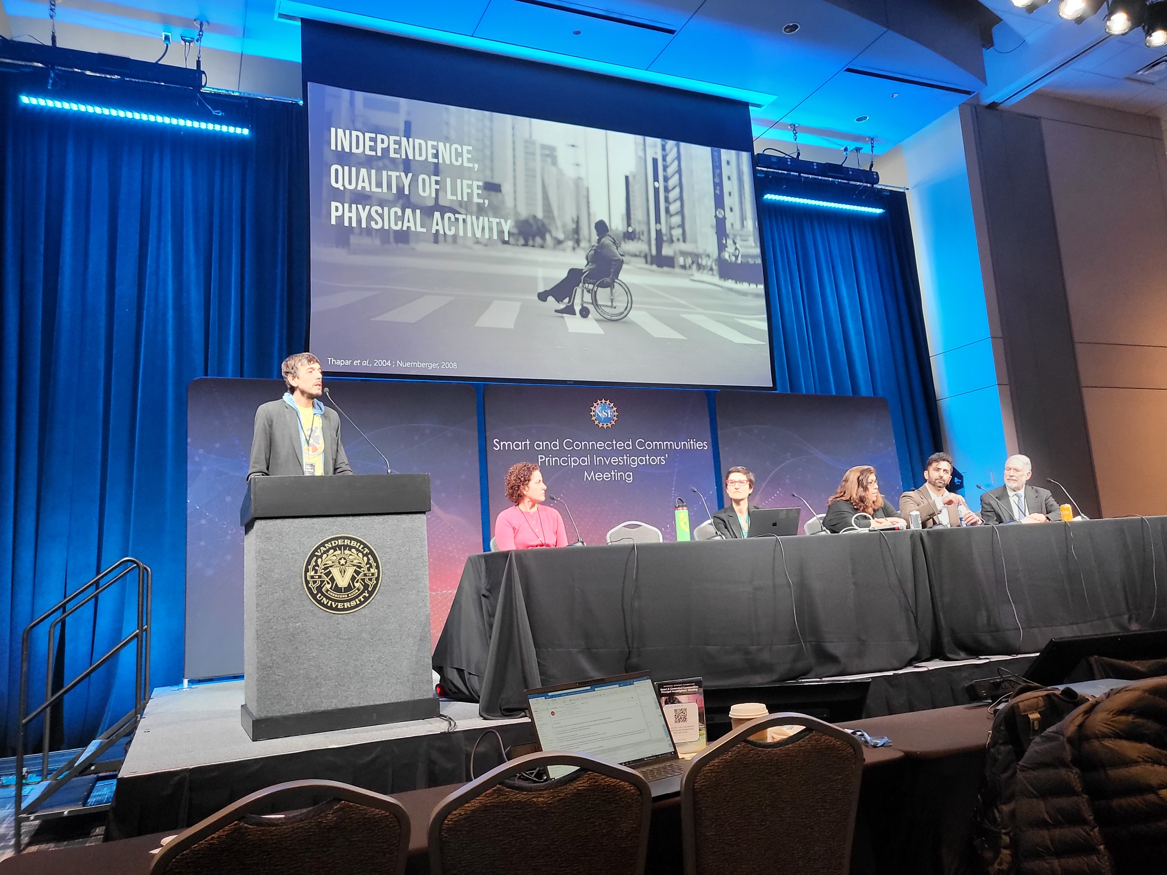 Jon standing on stage at NSF SCC giving presentation
